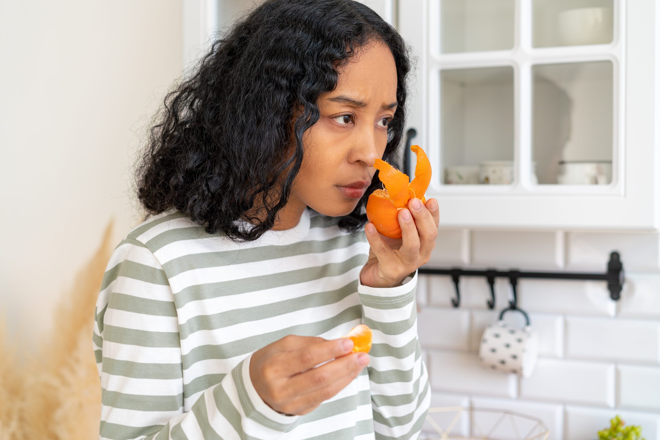 woman trying to smell orange peel